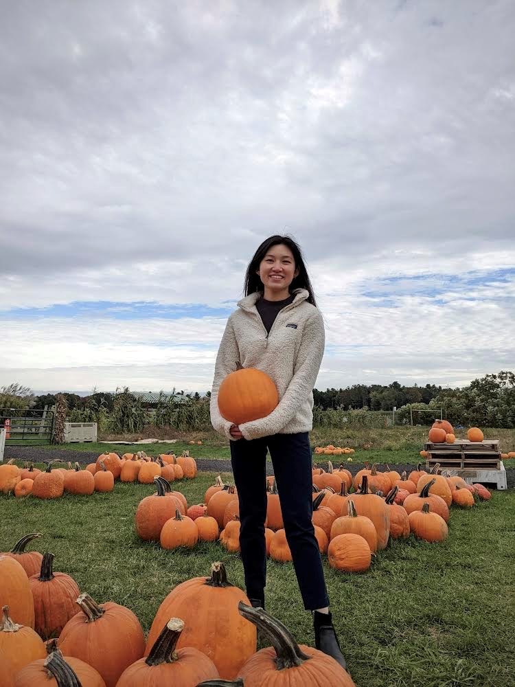 person posing for a photo with pumpkins