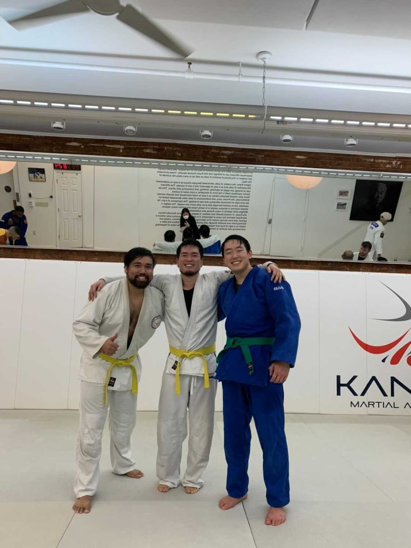 three people in karate robes posing for a photo